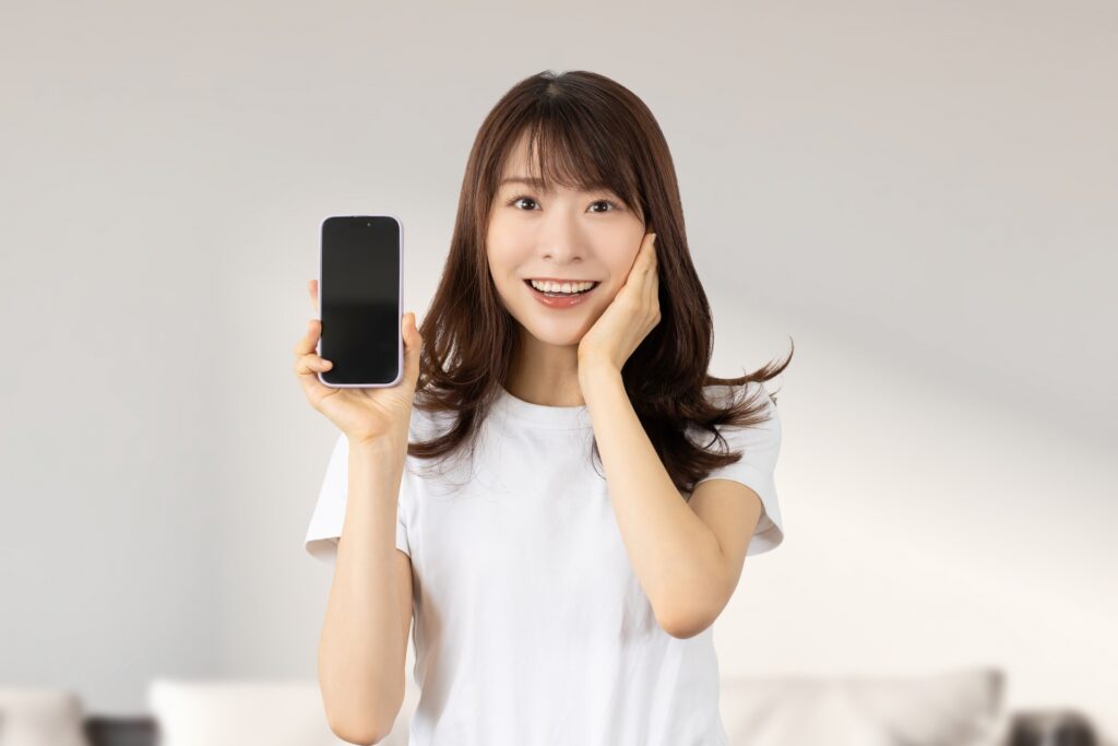 スマホを持っている笑顔の女性