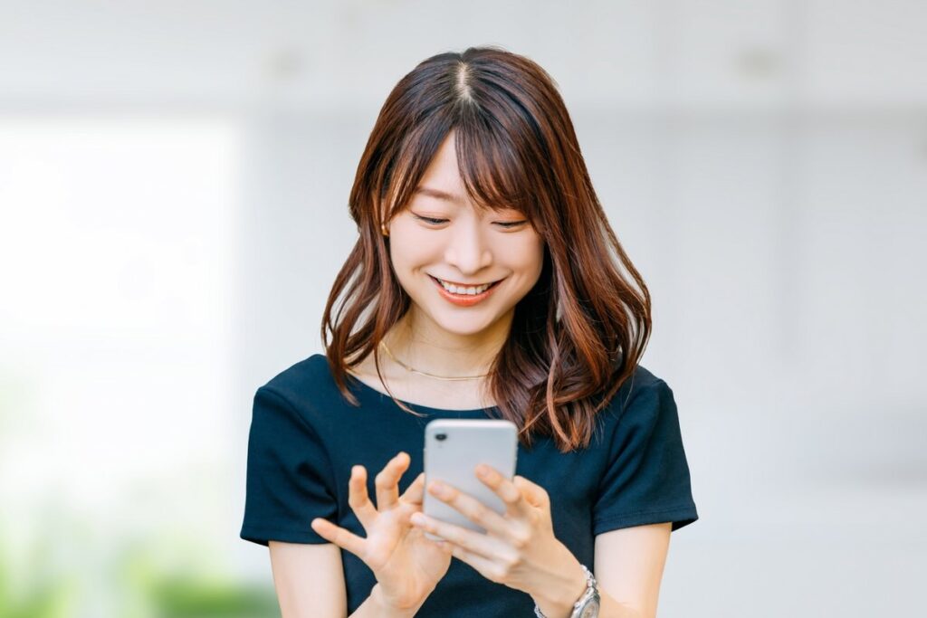 スマホを見て笑顔の女性