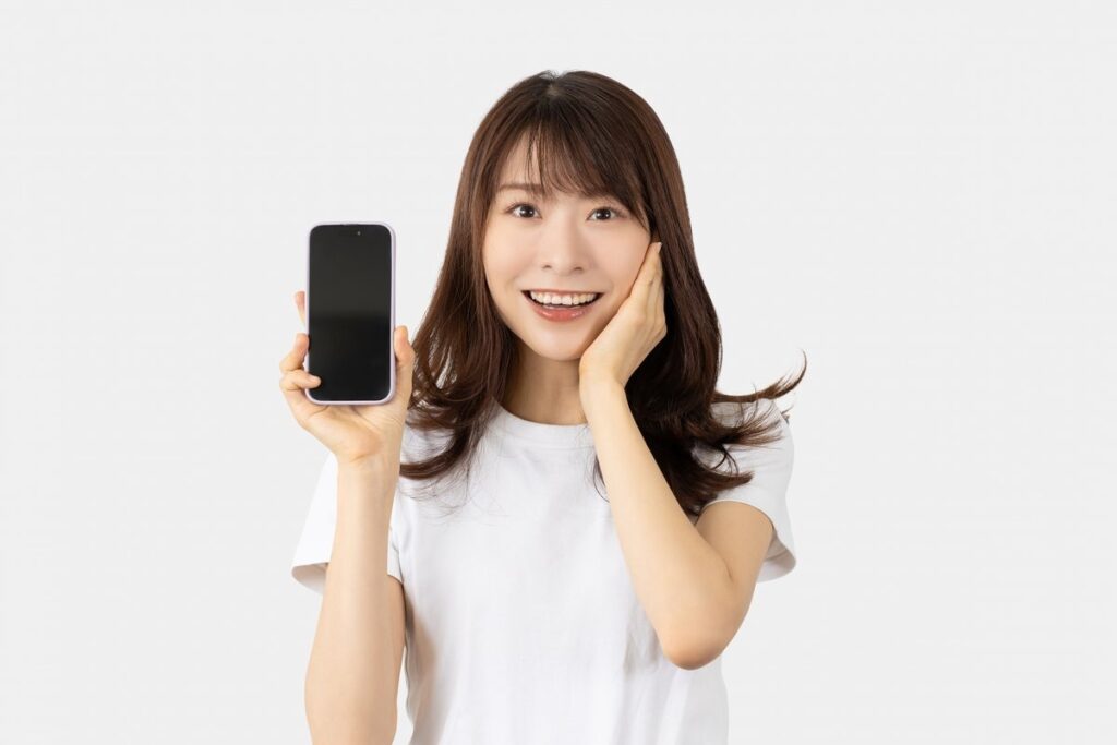 スマホを掲げている笑顔の女性