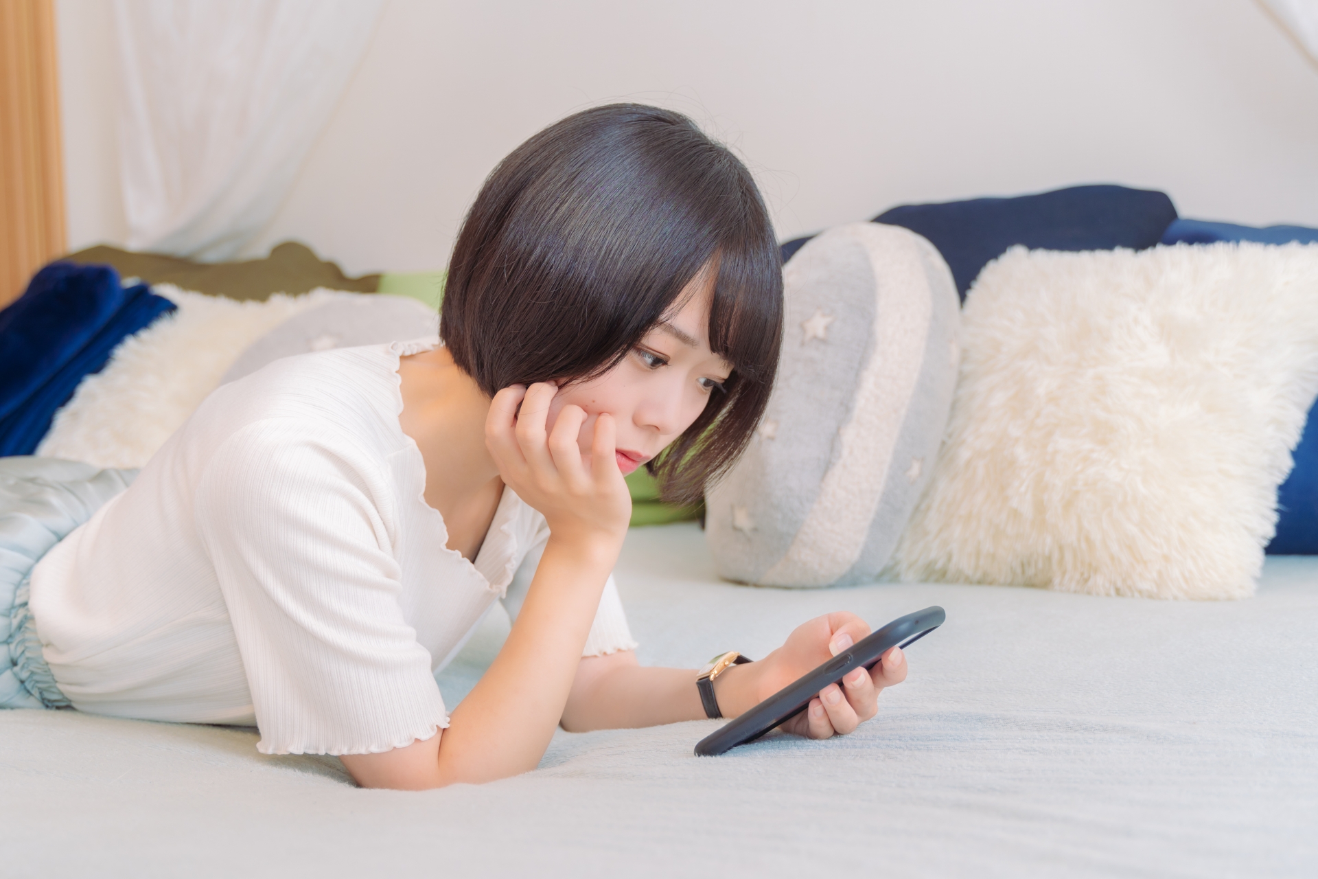 スマホを見ながら悩む女性