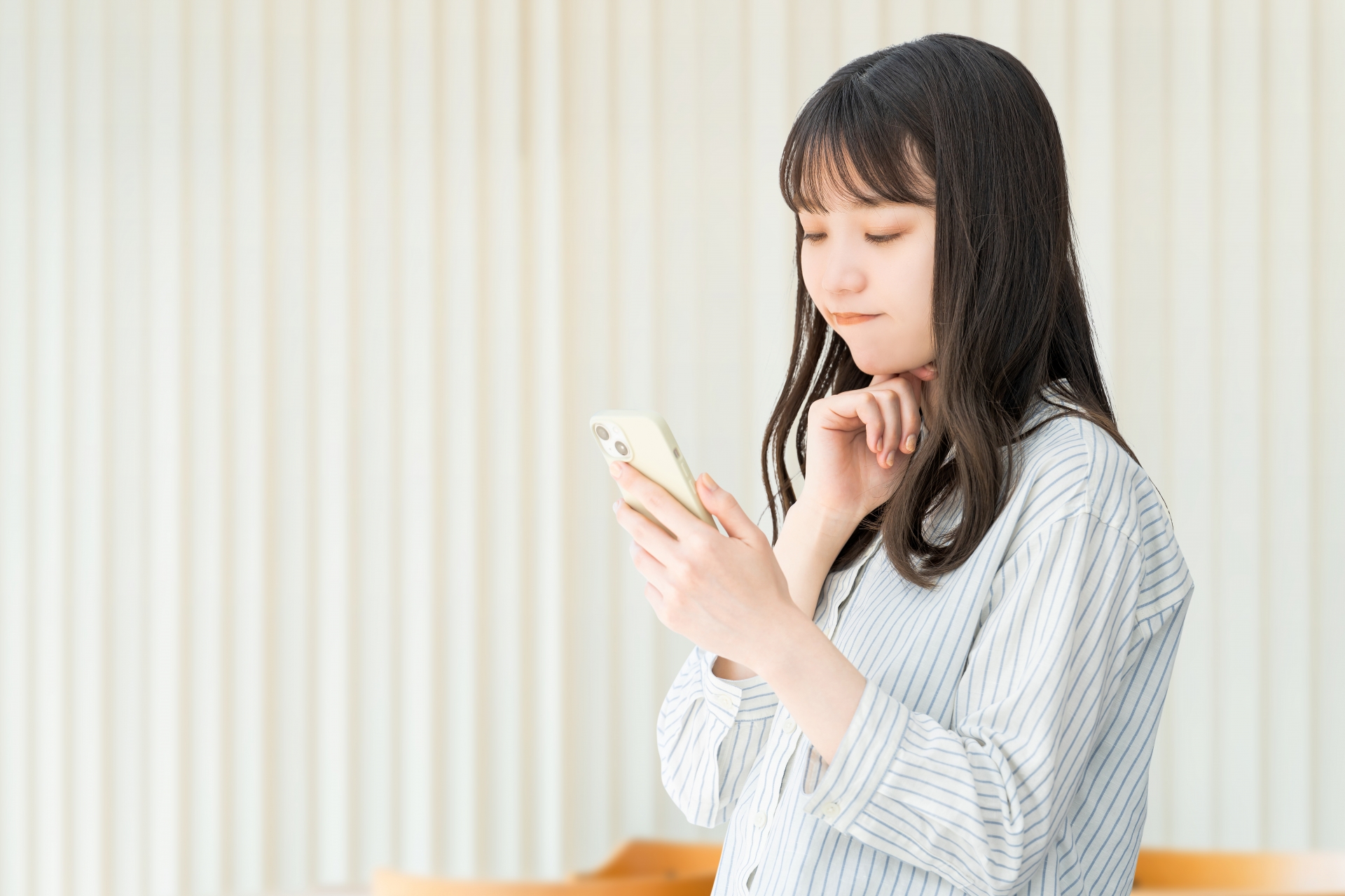 スマホを見て考える女性