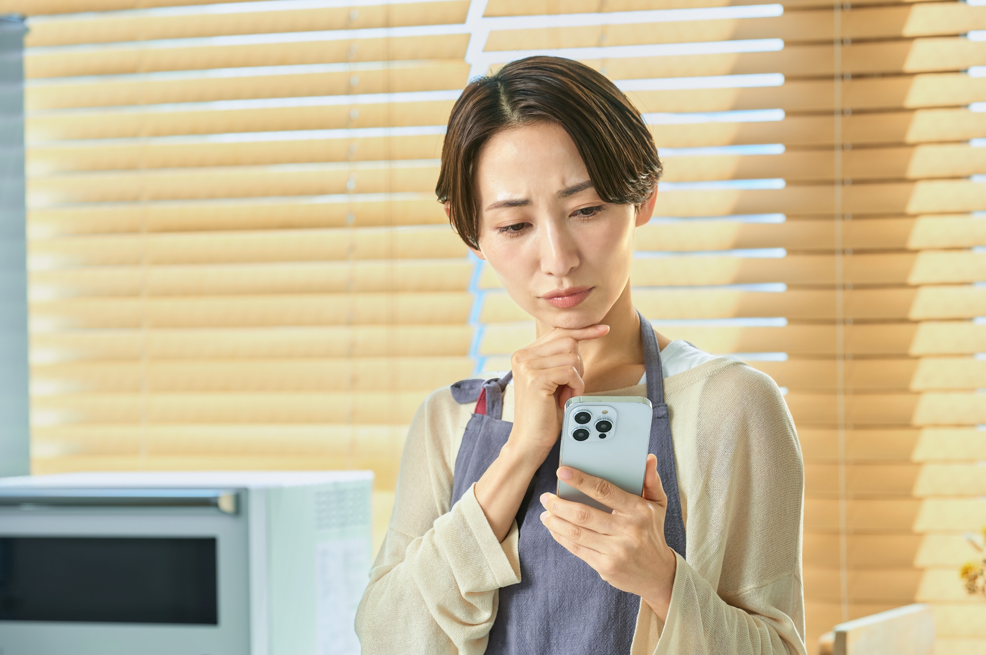 スマホを見て考え込む女性