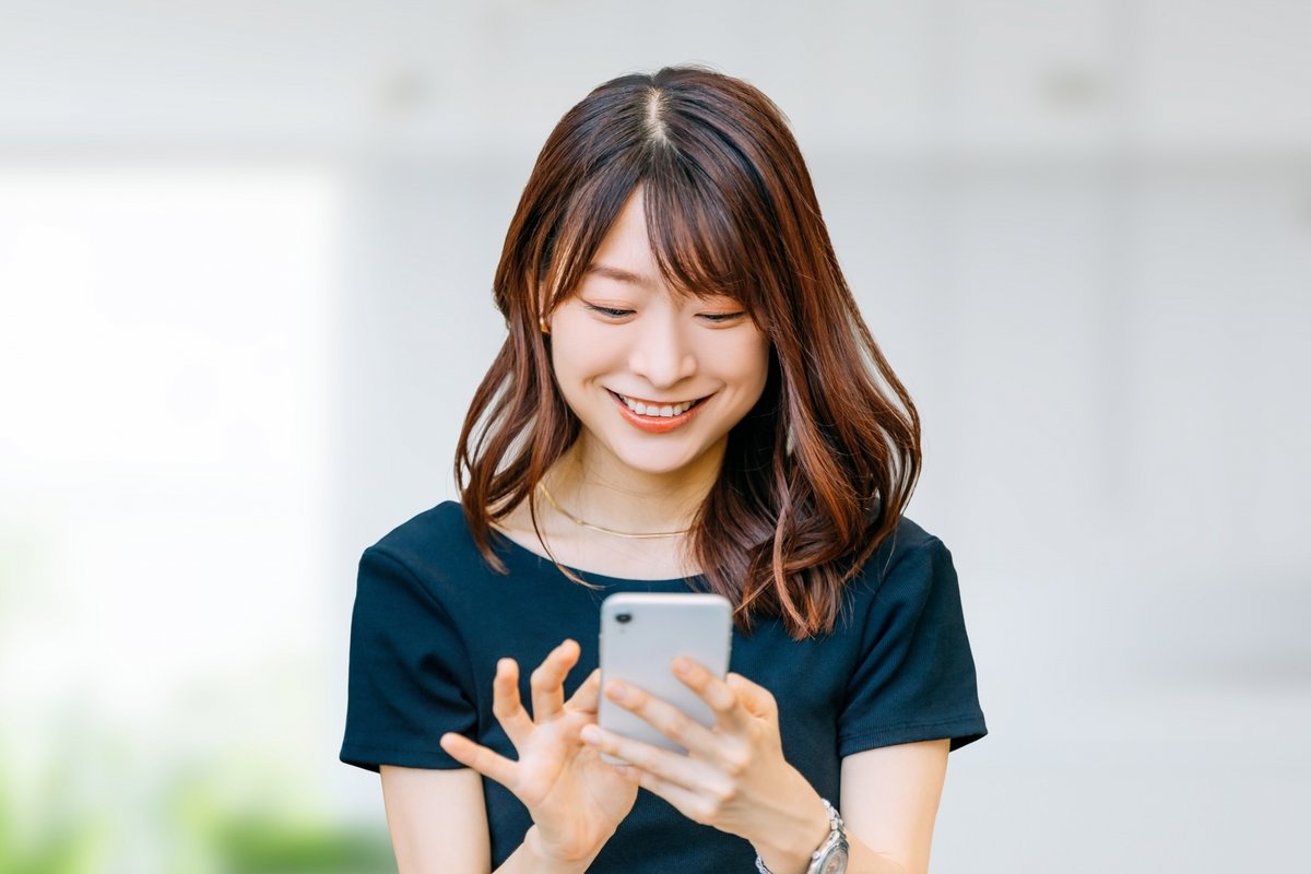 スマホを使う笑顔の女性